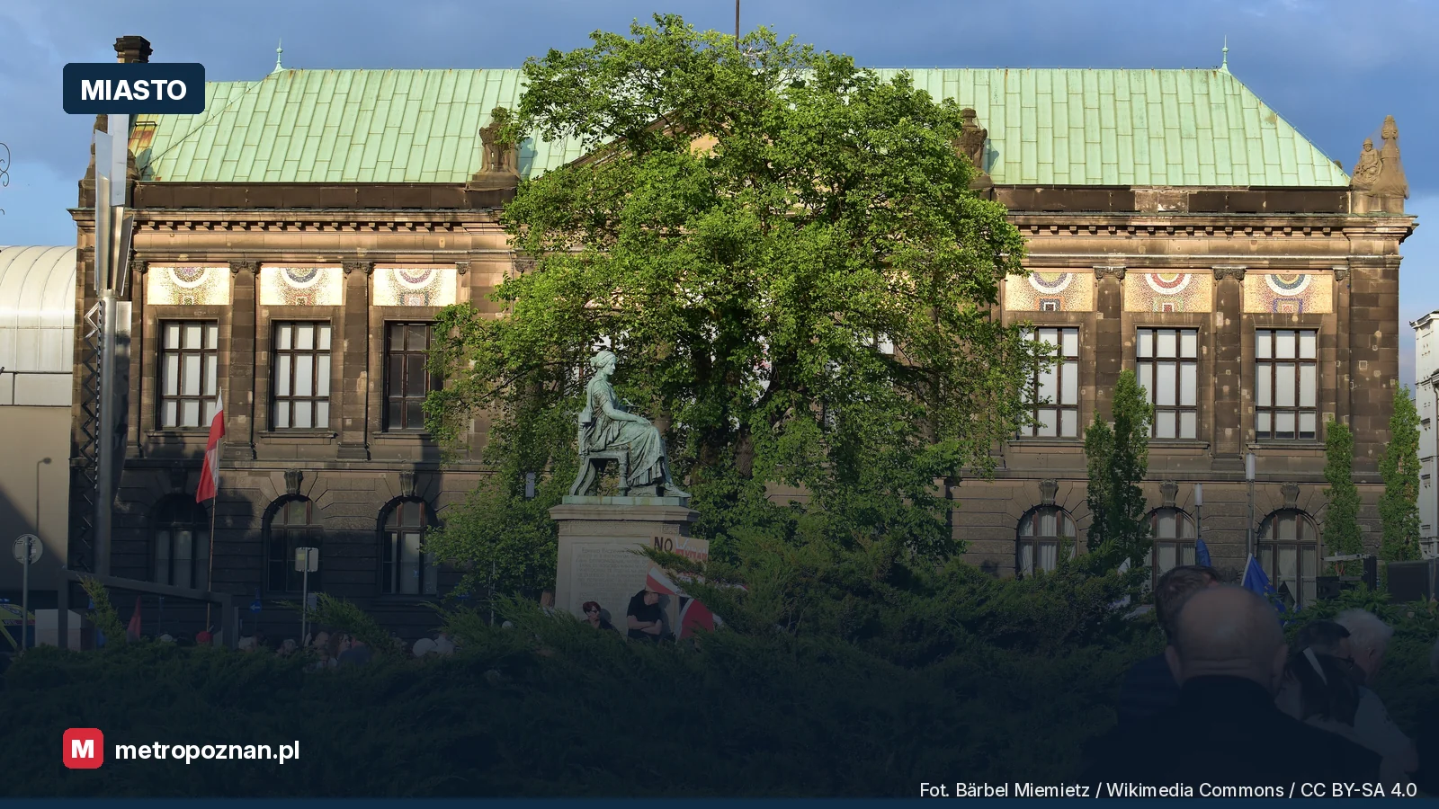Studnia Higiei na placu Wolności w Poznaniu, za nią drzewa i gmach Muzeum Narodowego
